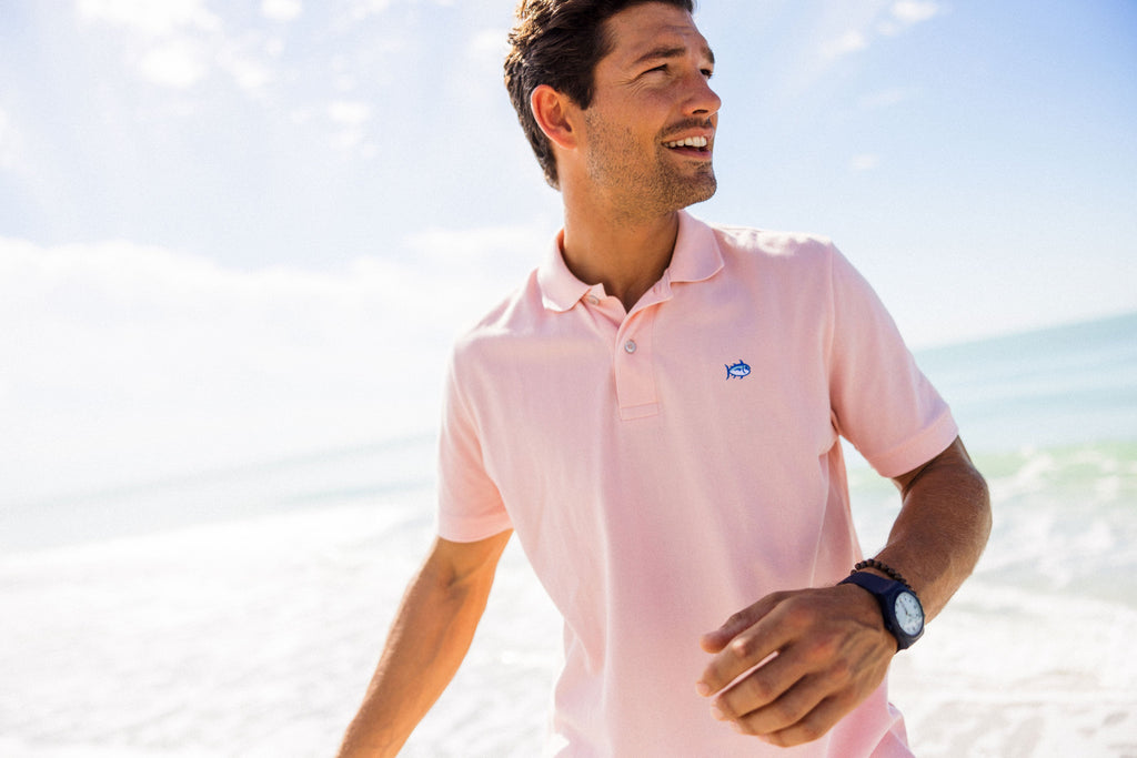 Man wearing Pink Skipjack Polo on the beach.