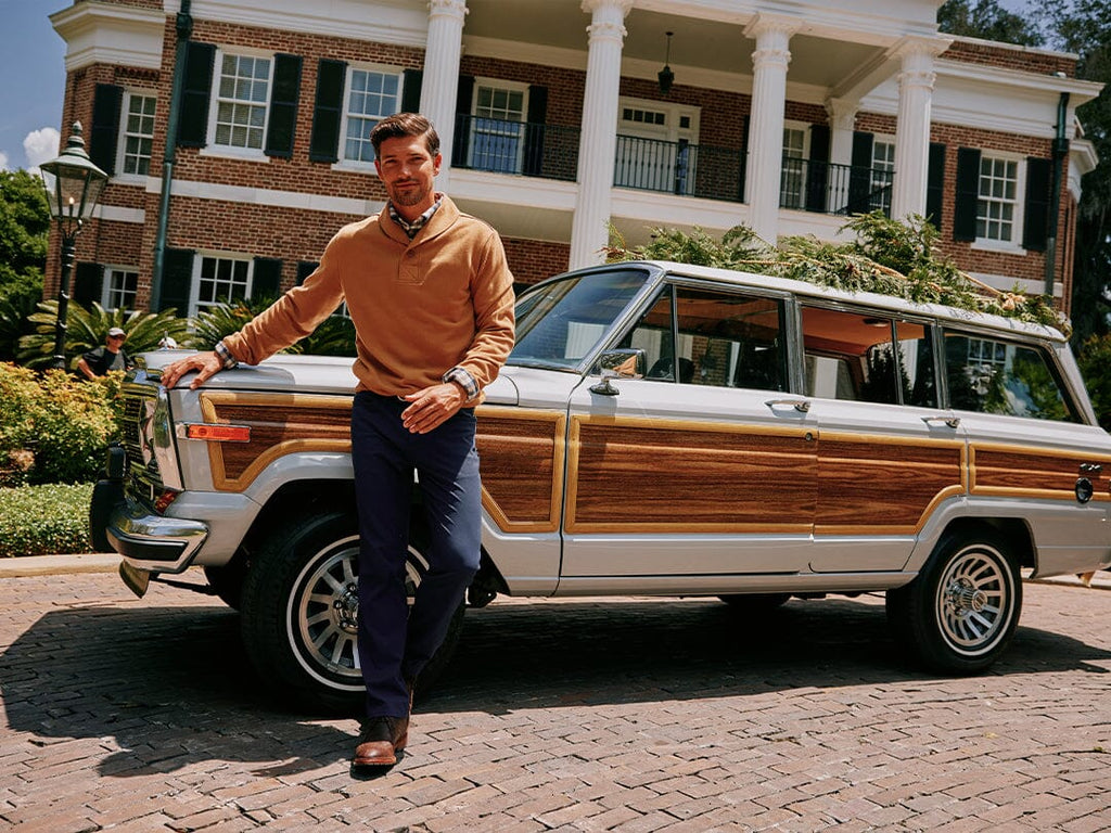 Man wearing sports shirt sitting on porch steps holding a gift.