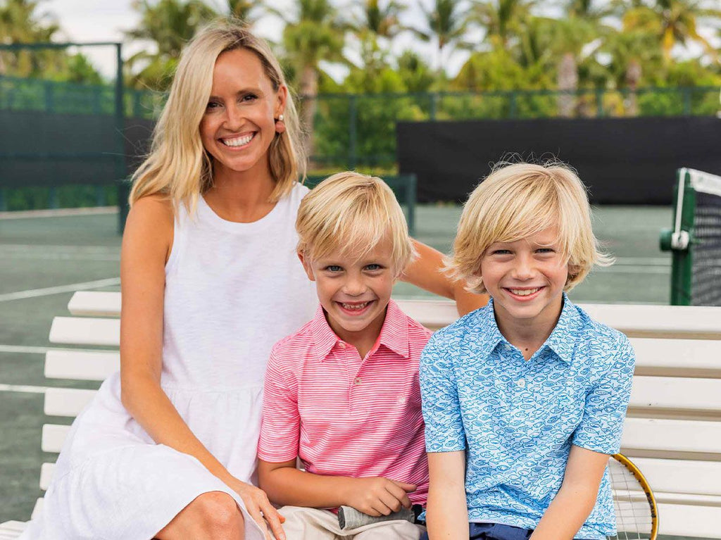 Woman siting on bench with two sons.