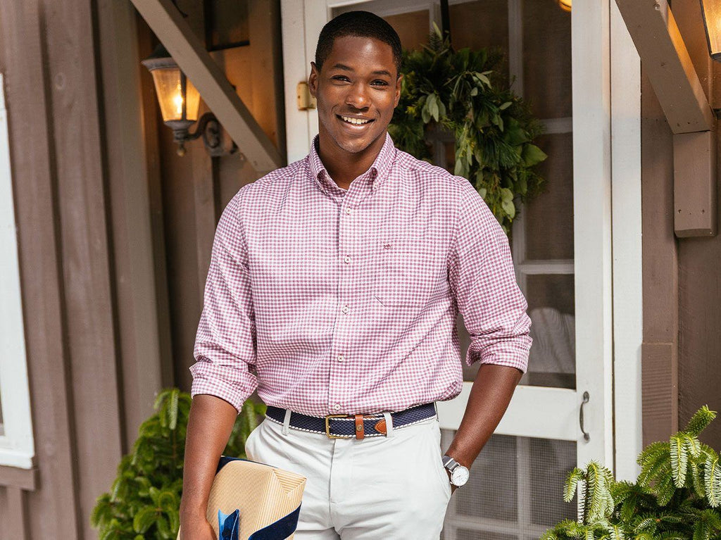 Man wearing sports shirt smiling at camera holing gift.