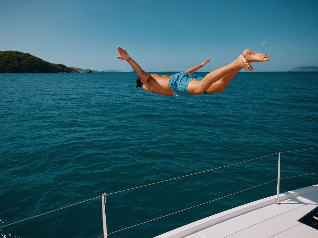 Man diving into water wearing Fintastic swim trunk.