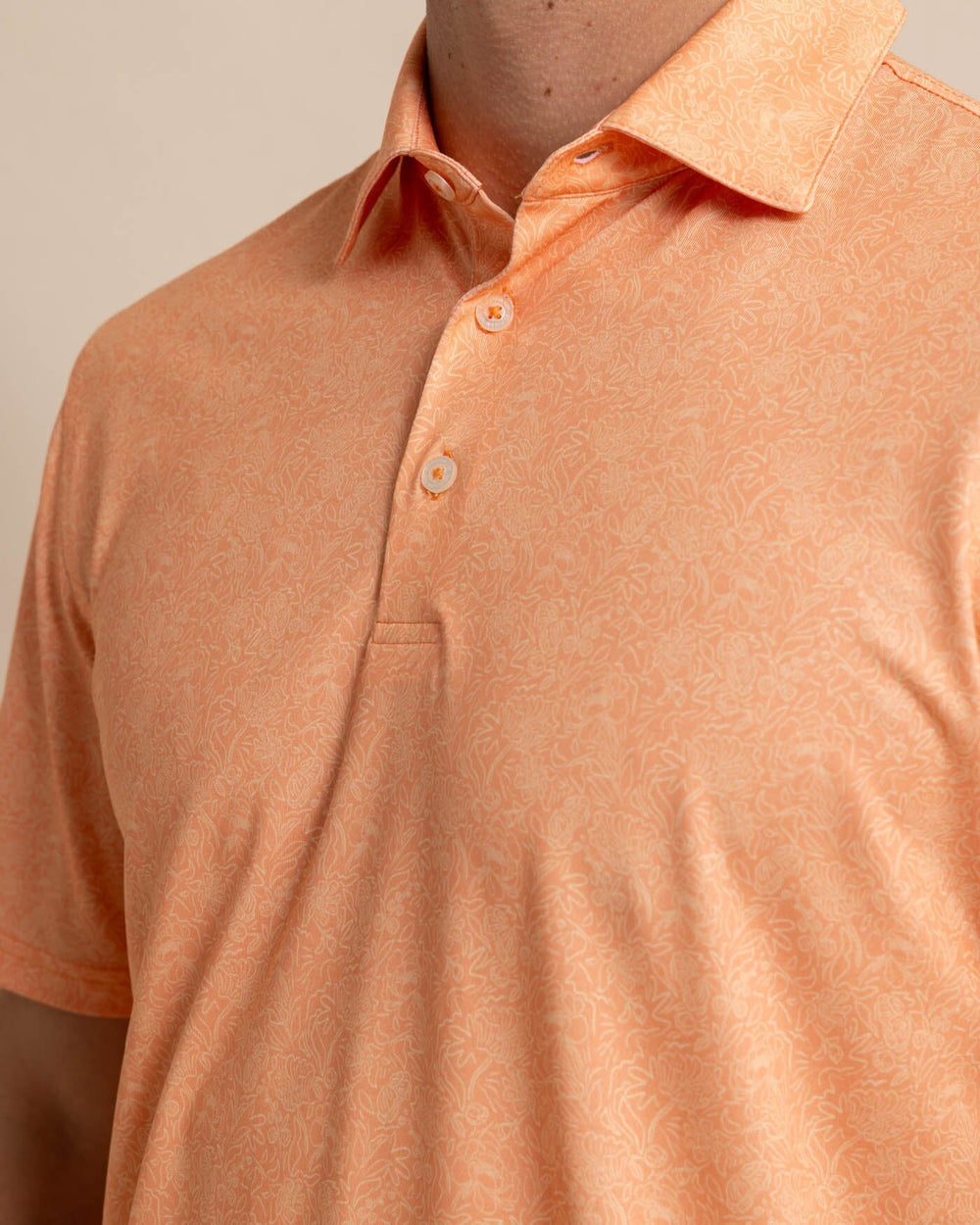 The detail view of the Southern Tide Driver Sunny Blooms Polo Shirt by Southern Tide - Tangerine Orange