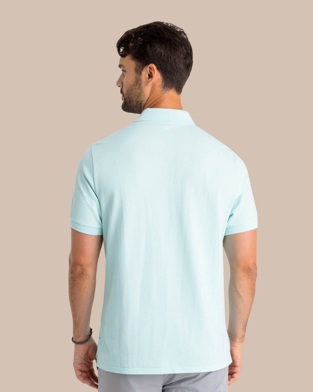 The model back view of the Men's New Skipjack Polo Shirt by Southern Tide - Baltic Teal